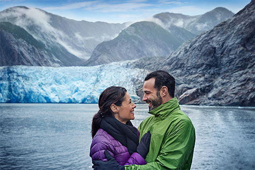 Pareja disfrutando de un glaciar de Alaska. EworldCruises.com Pareja disfrutando de un glaciar de Alaska. EworldCruises.com